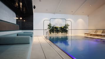 Área da piscina com espaço de estar com espreguiçadeiras, placa indicando o Grand Hotel de Courtoisville e um arranjo de plantas decorativas.
