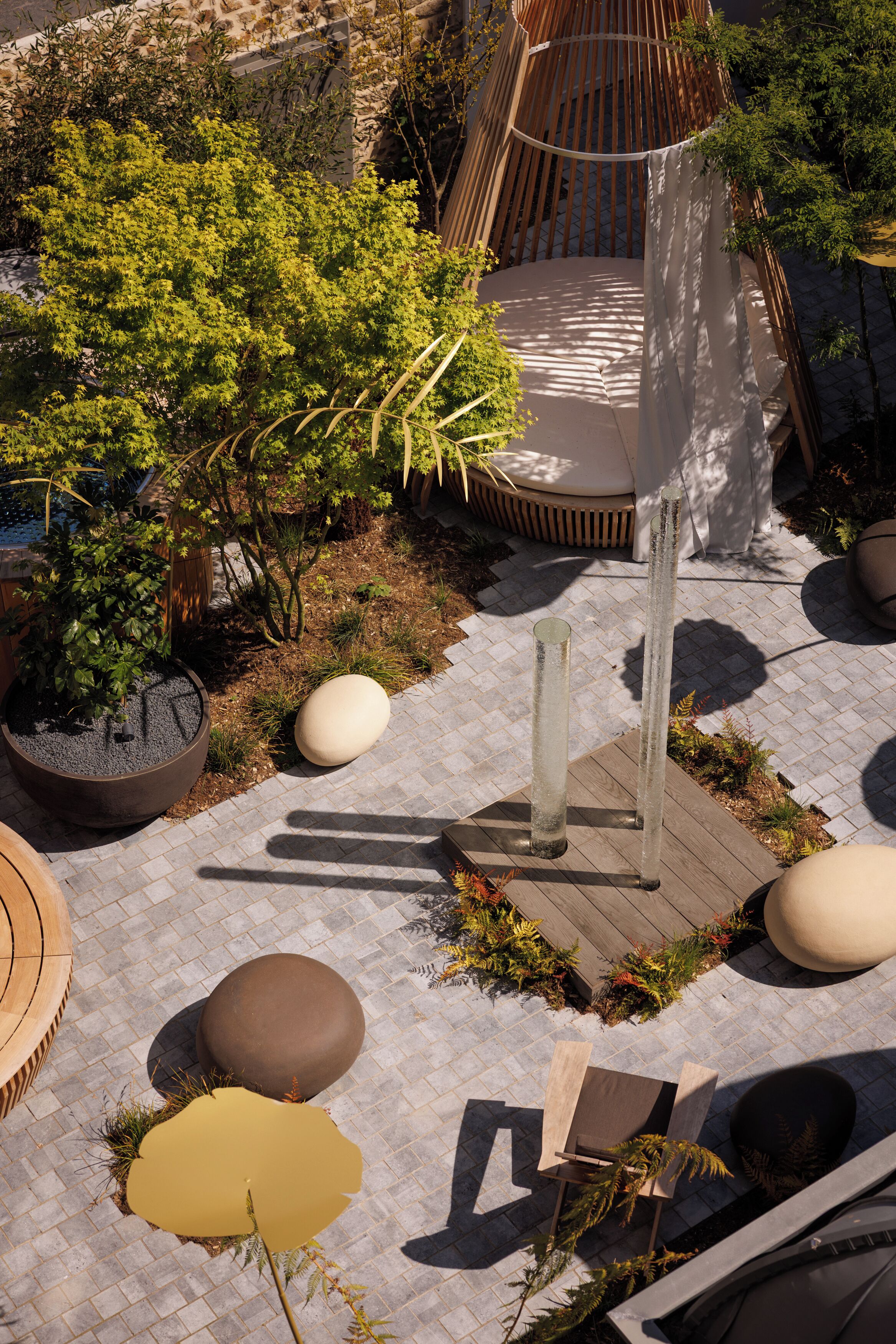 Uma área de jardim com plantas em vasos, um deck de madeira e um espaço para sentar.