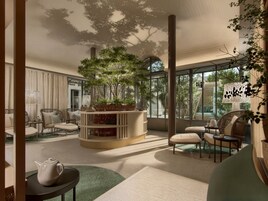 Un interior moderno con una planta en el centro, asientos y vistas amplias a través de grandes ventanales.