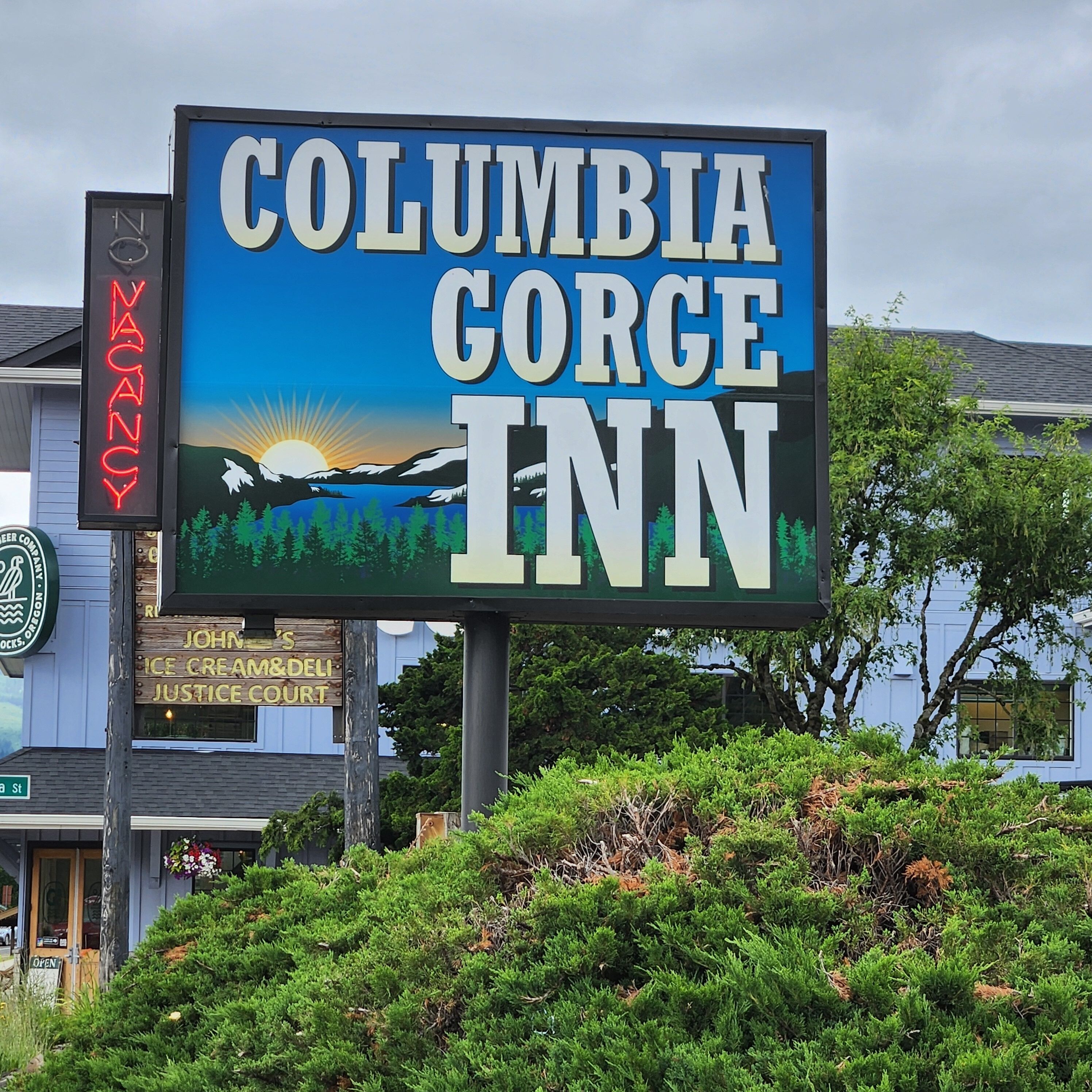 Señal del Columbia Gorge Inn con una ilustración del paisaje al atardecer.