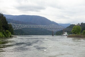 A steel truss bridge over a river with a boat on the right. - Columbia Gorge Inn (Cascade Locks)