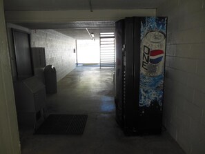 A hallway with a vending machine, a trash bin, and a door leading to another area. - Wagner Inn (Eureka Springs)