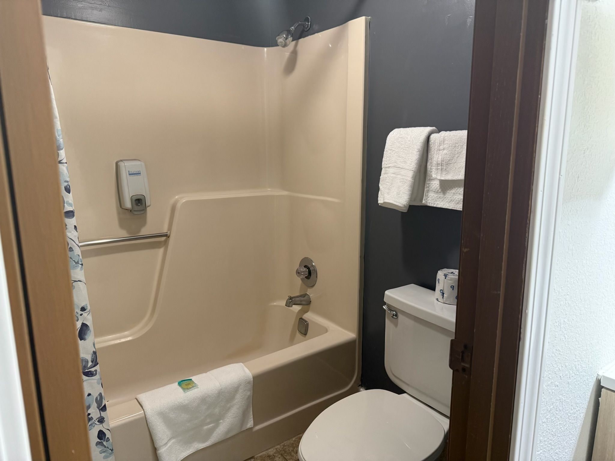 A bathroom with a bathtub, toilet, and a towel rack.