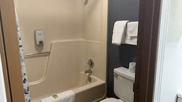 A bathroom with a bathtub, toilet, and a towel rack.