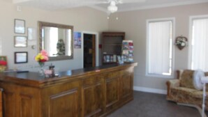 A living room with a wooden cabinet, a television, and a chair. - Wagner Inn (Eureka Springs)