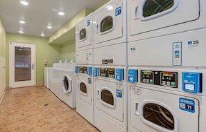 A laundry facility with multiple washing machines, each with a digital display and a QR code for the CSCPay Mobile app. - Extended Stay America Select Suites - Indianapolis - Greenwood (Greenwood)