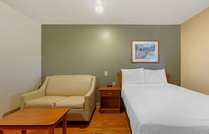 A room with a bed, a sofa, a nightstand, and a small table. - Extended Stay America Select Suites - Indianapolis - Greenwood (Greenwood)