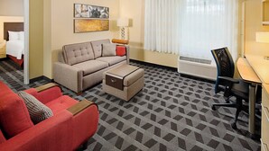 Ein Hotelzimmer mit einer Couch, einem Sessel, einem Schreibtisch und einem Bett.