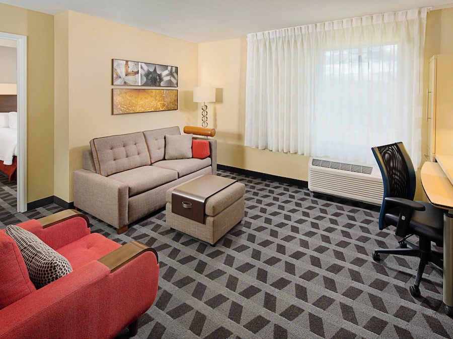 Habitación de hotel con sofá, silla, escritorio y cama.