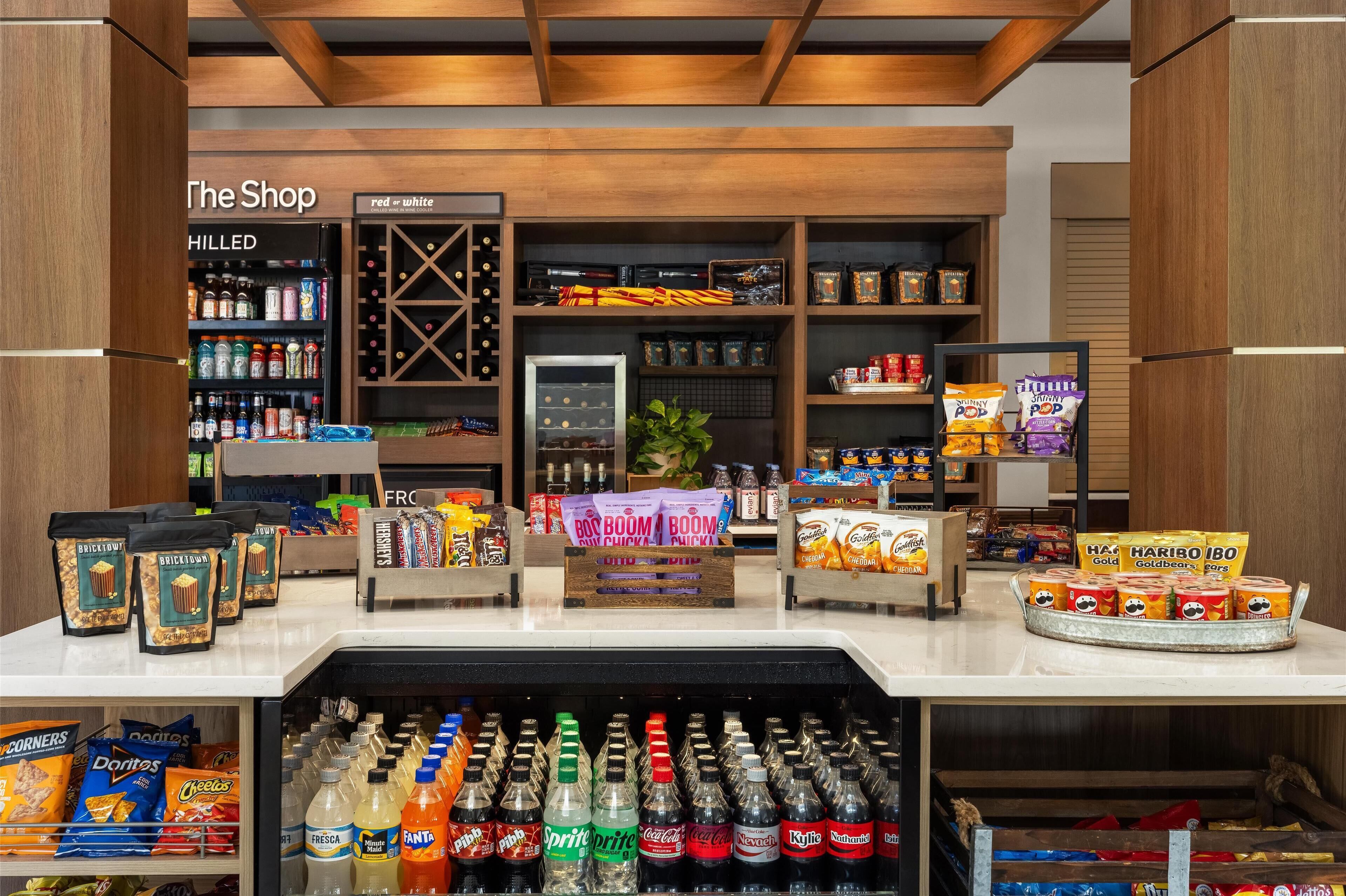 A snack and beverage display area with various snacks, drinks, and a refrigerated section.