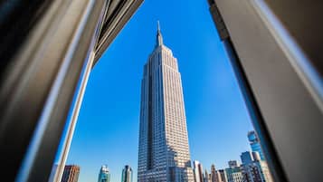 Un edificio alto con aguja, rodeado de otros edificios.