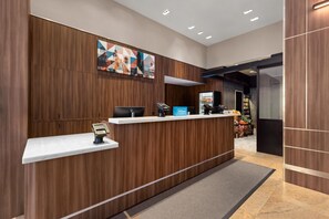 Een receptiebalie met een modern design, een digitale kiosk en een minibar.