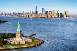 La statue de la Liberté, sur l’île de la Liberté, avec la silhouette de New York en arrière-plan.