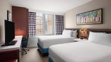 A hotel room with two beds, a desk with a flat-screen TV, a window with curtains, and a painting on the wall.