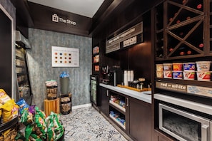 L'intérieur d'un café, avec une machine à café, un présentoir de collations et un panneau indiquant les différents types de café proposés.