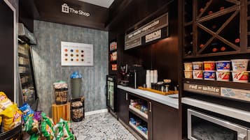 Interior de una cafetería con un letrero que indica 'The Shop' y una pizarra con los tipos de café.
