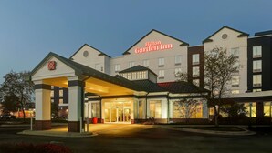 A Hilton Garden Inn with a modern architectural design, featuring a prominent entrance and a well-lit facade. - Hilton Garden Inn Indianapolis Airport (Indianapolis)