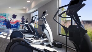 A gym with multiple treadmills, a large abstract painting, and large windows offering a view of the outdoors. - Hampton Inn & Suites Cleveland Mentor (Mentor)