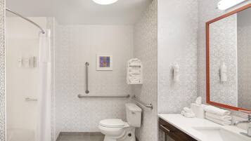 A bathroom with a toilet, sink, and shower.