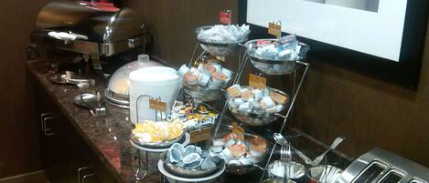 A buffet setup with various food items and a toaster.