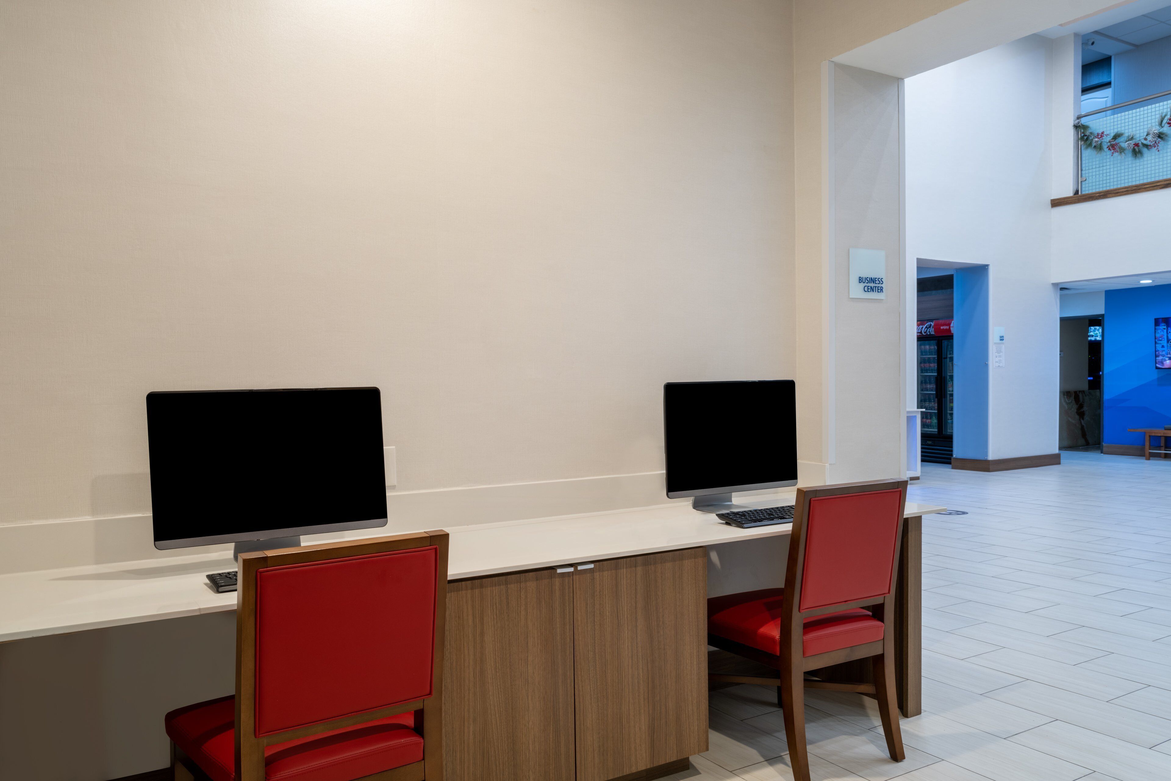 Un espace de bureau moderne comprenant deux bureaux, chacun équipé d’un ordinateur et d’une chaise.