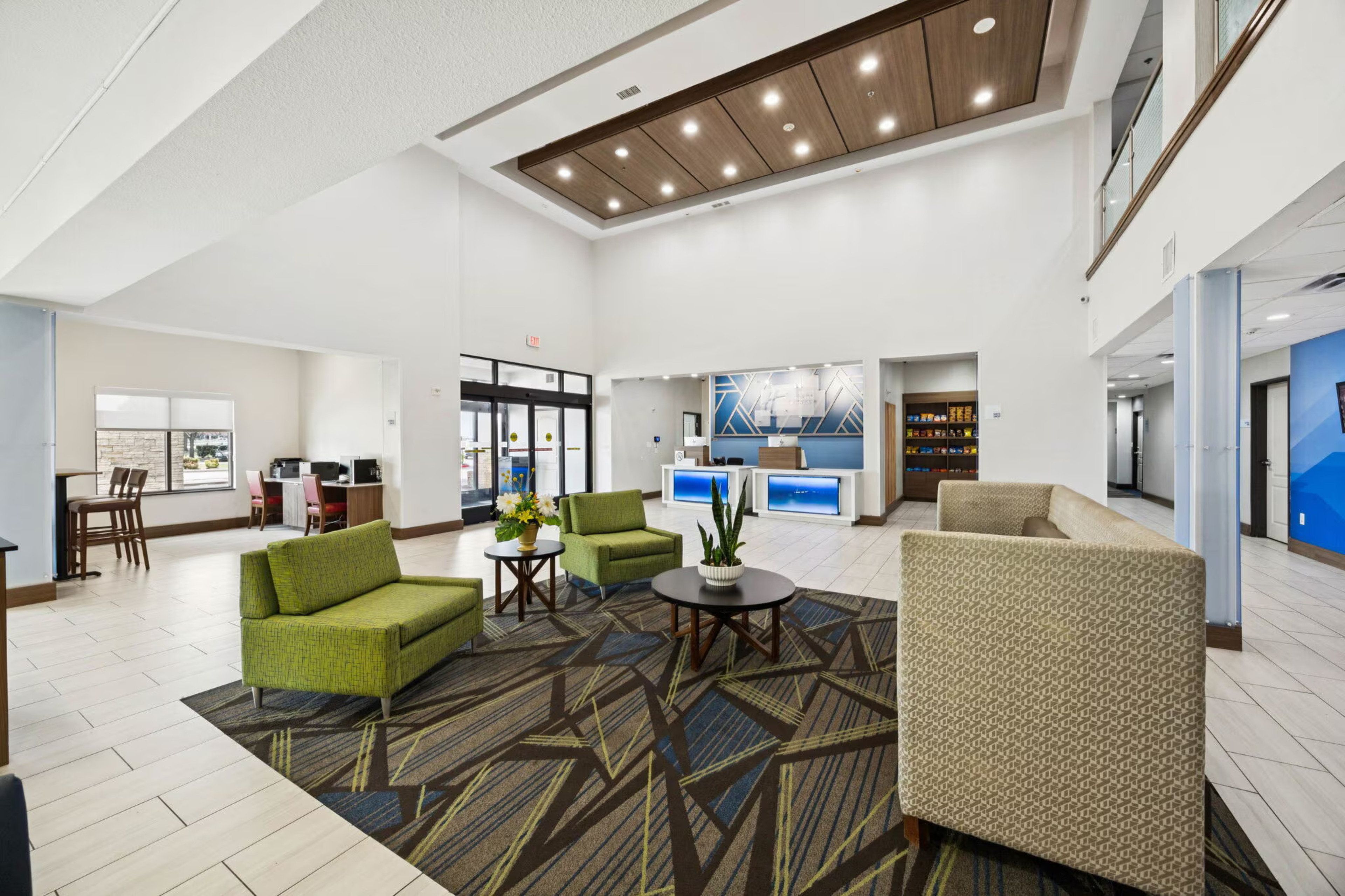 A spacious lobby with seating areas, a reception desk, and a view of the cityscape.