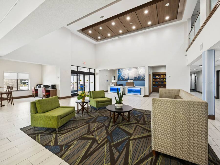 A spacious lobby with seating areas, a reception desk, and a view of the cityscape.