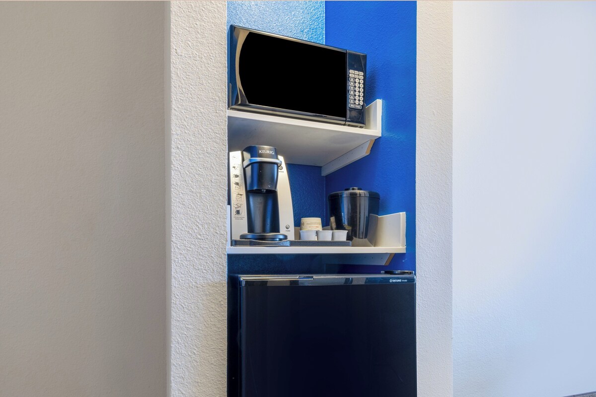 A kitchenette with a microwave, coffee maker, and a refrigerator.