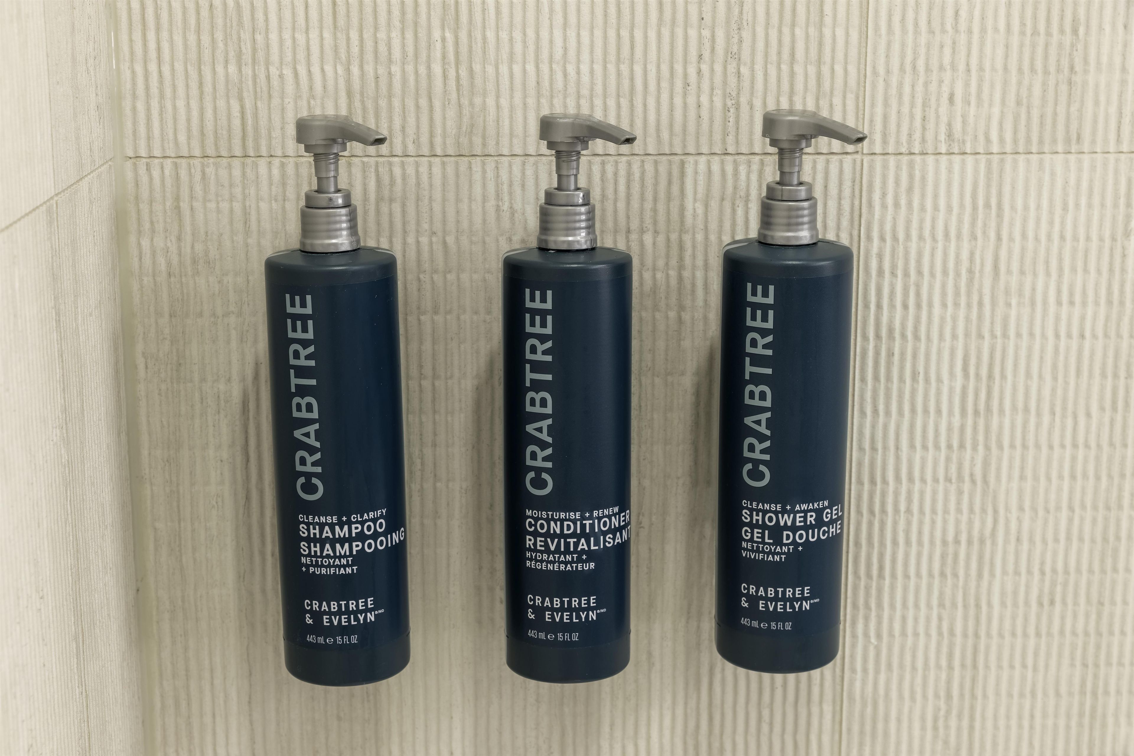 Three bottles of Crabtree & Evelyn shampoo and conditioner.
