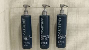 Three bottles of Crabtree & Evelyn shampoo and conditioner.