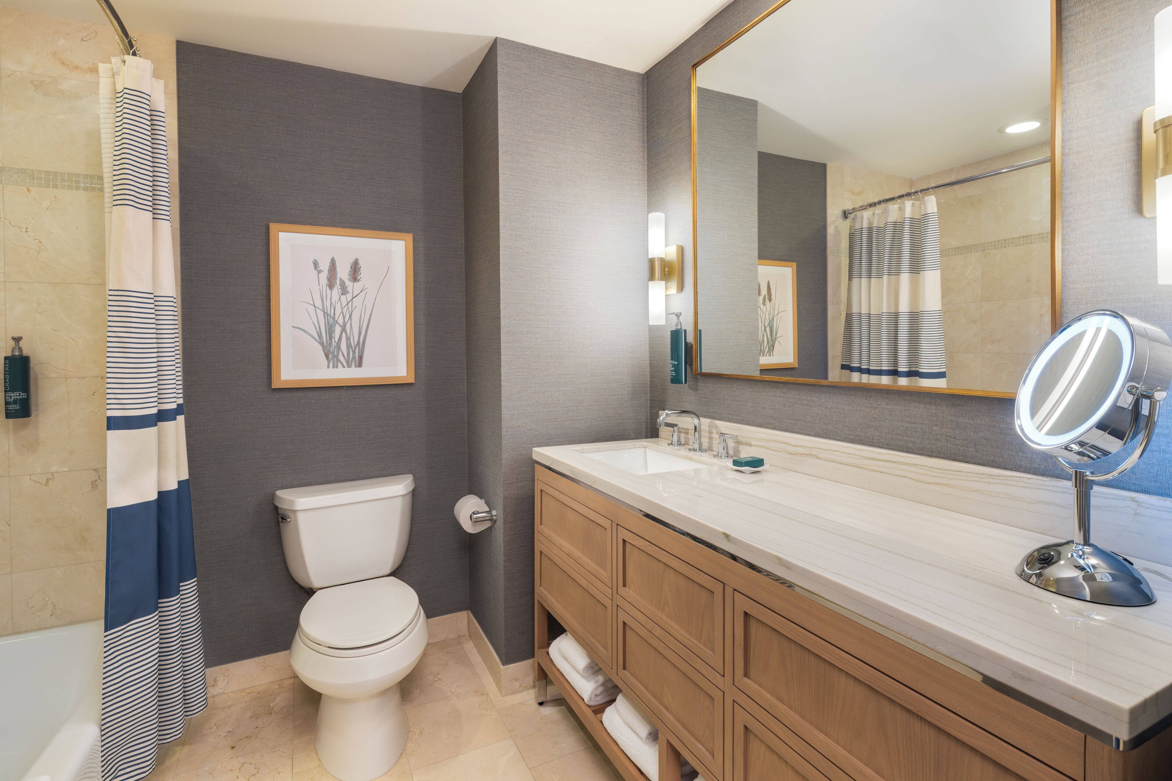 A bathroom with a toilet, a sink with a mirror, and a shower curtain.