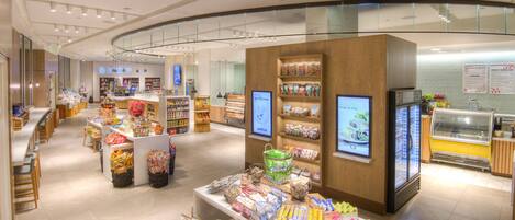 A modern shopping area with a central display, glass railings, and a refrigerated section.