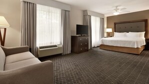 Une chambre d’hôtel avec un lit, une télévision, un bureau et une chaise.
