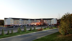 Un hôtel à plusieurs étages doté d’une entrée principale, d’un parking et d’un espace extérieur aménagé.