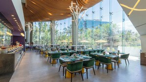 Un amplio comedor interior con muebles modernos, ventanas grandes y un diseño de techo único.