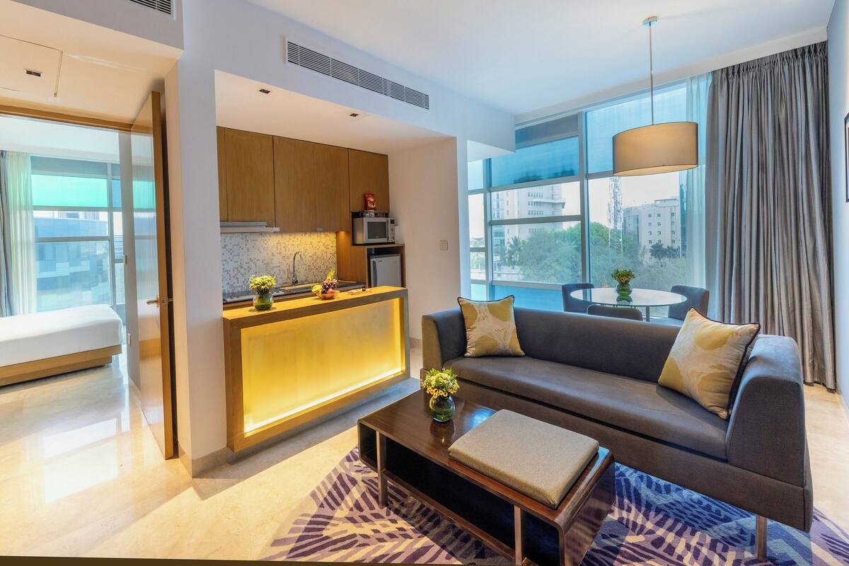 A modern living room with a sofa, a coffee table, and a view of the city.