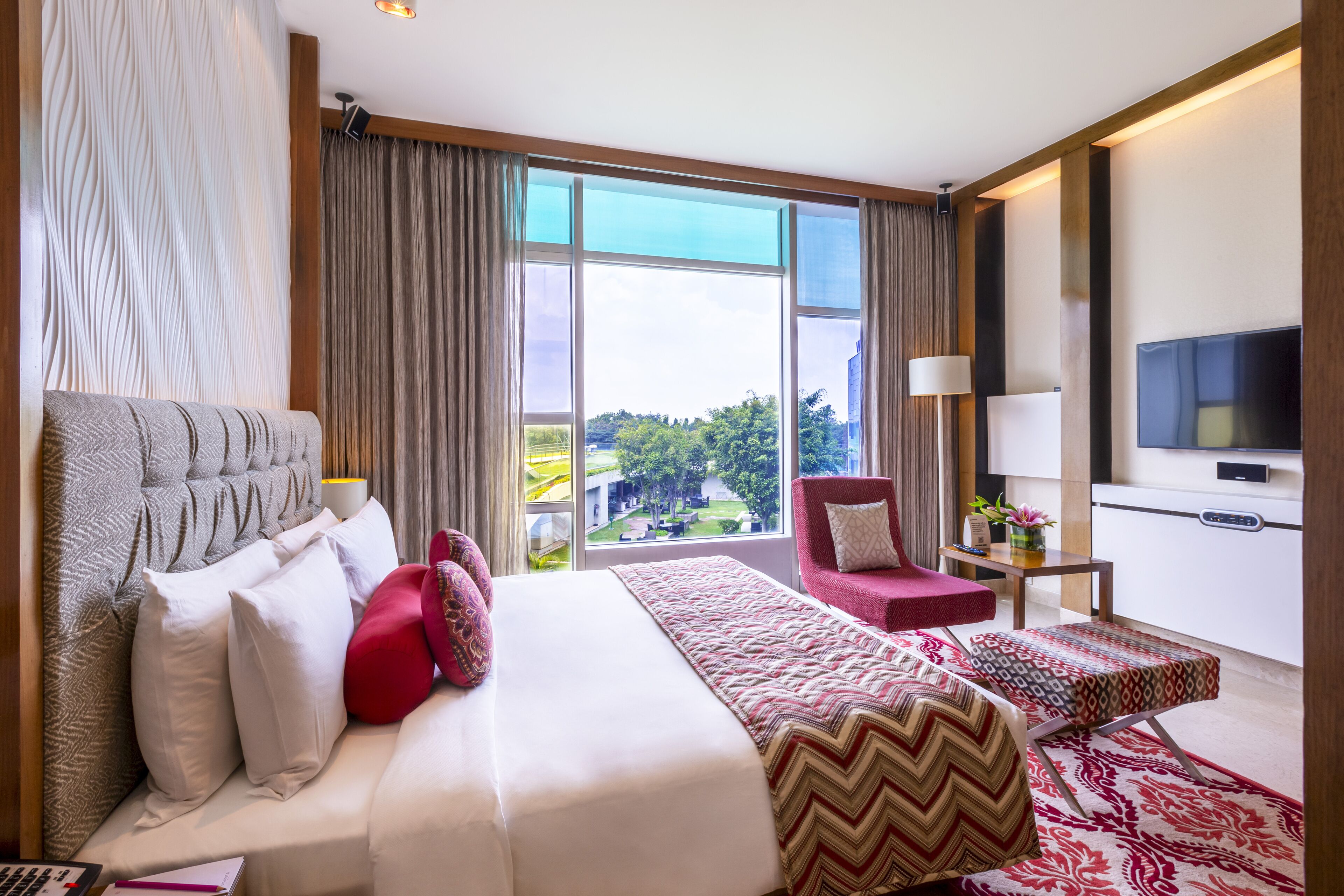 deluxe room garden view queen bed | premium bedding, minibar, in-room safe, individually decorated