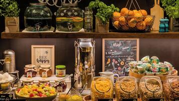 A buffet with various food options including fruit salad, cornflakes, and honey.