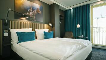 A hotel room with a large bed, a headboard, a nightstand, a desk, a chair, a lamp, a painting, and a view of the Eiffel Tower.