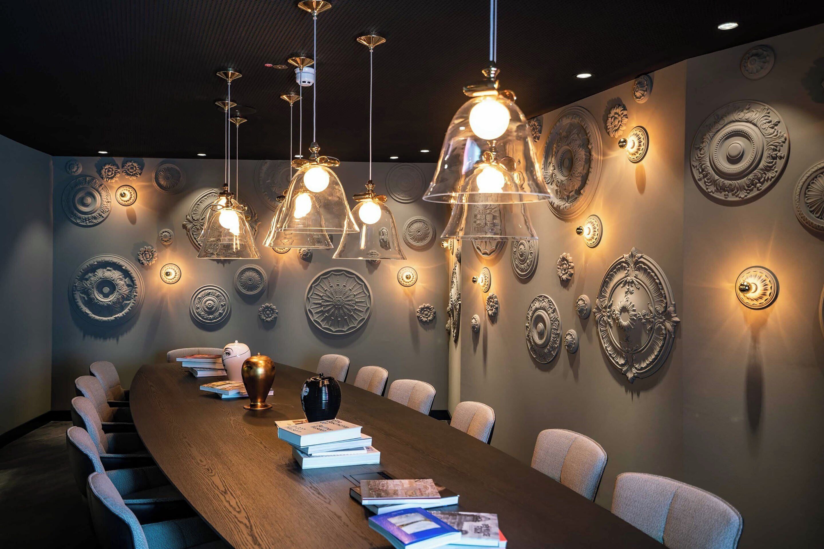 A conference room with a long table, chairs, and decorative wall plates.