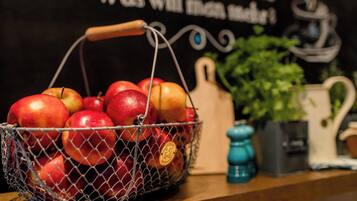 A basket of apples on a wooden surface with a blackboard in the background.