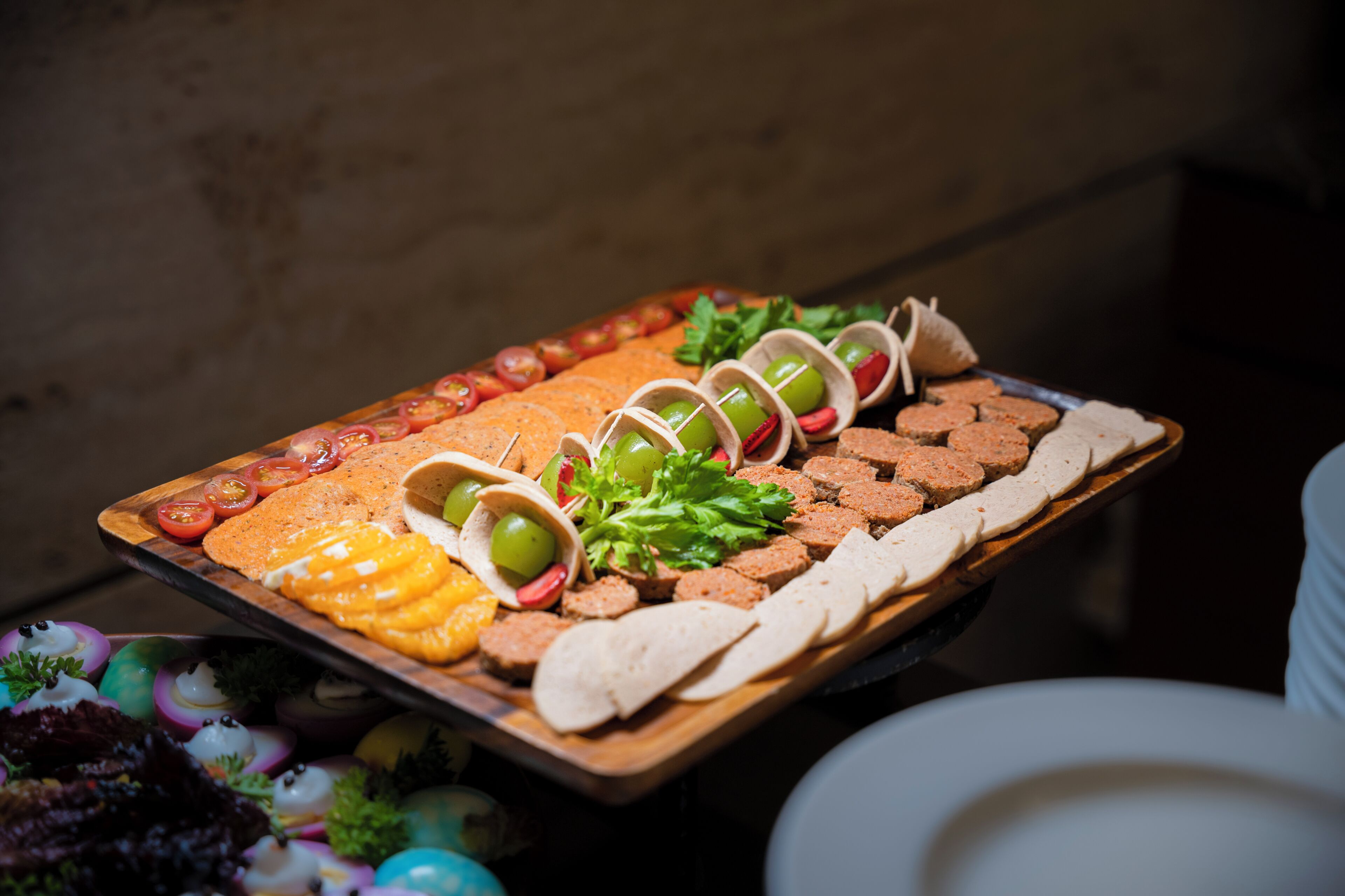 A tray of assorted food items including bread, olives, and vegetables.