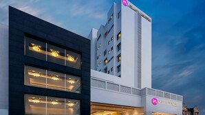A modern hotel with a prominent 'Grand Mercure' sign, large windows, and a well-lit entrance.