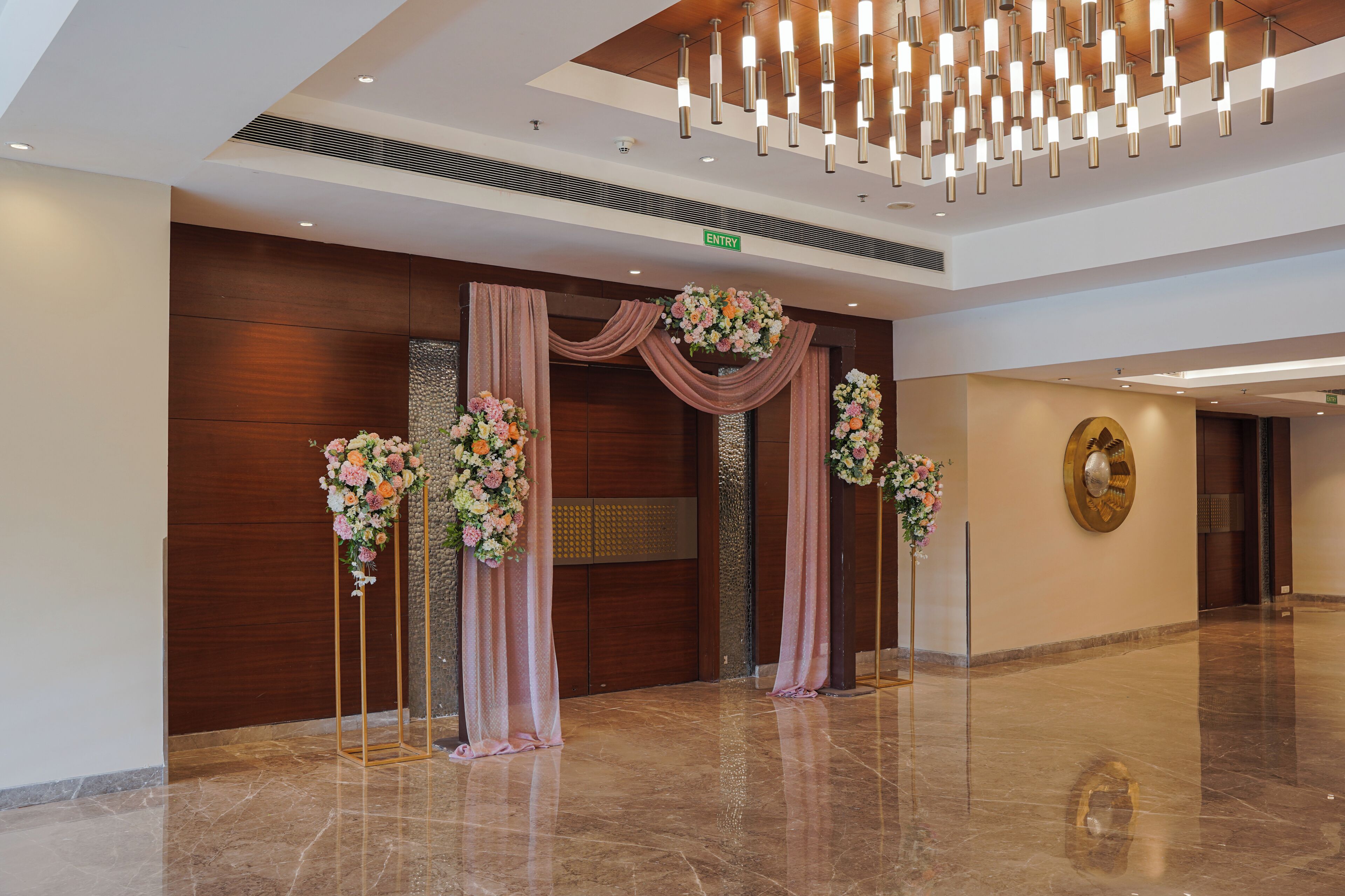 A lobby with a marble floor, a wooden reception desk, and a chandelier.