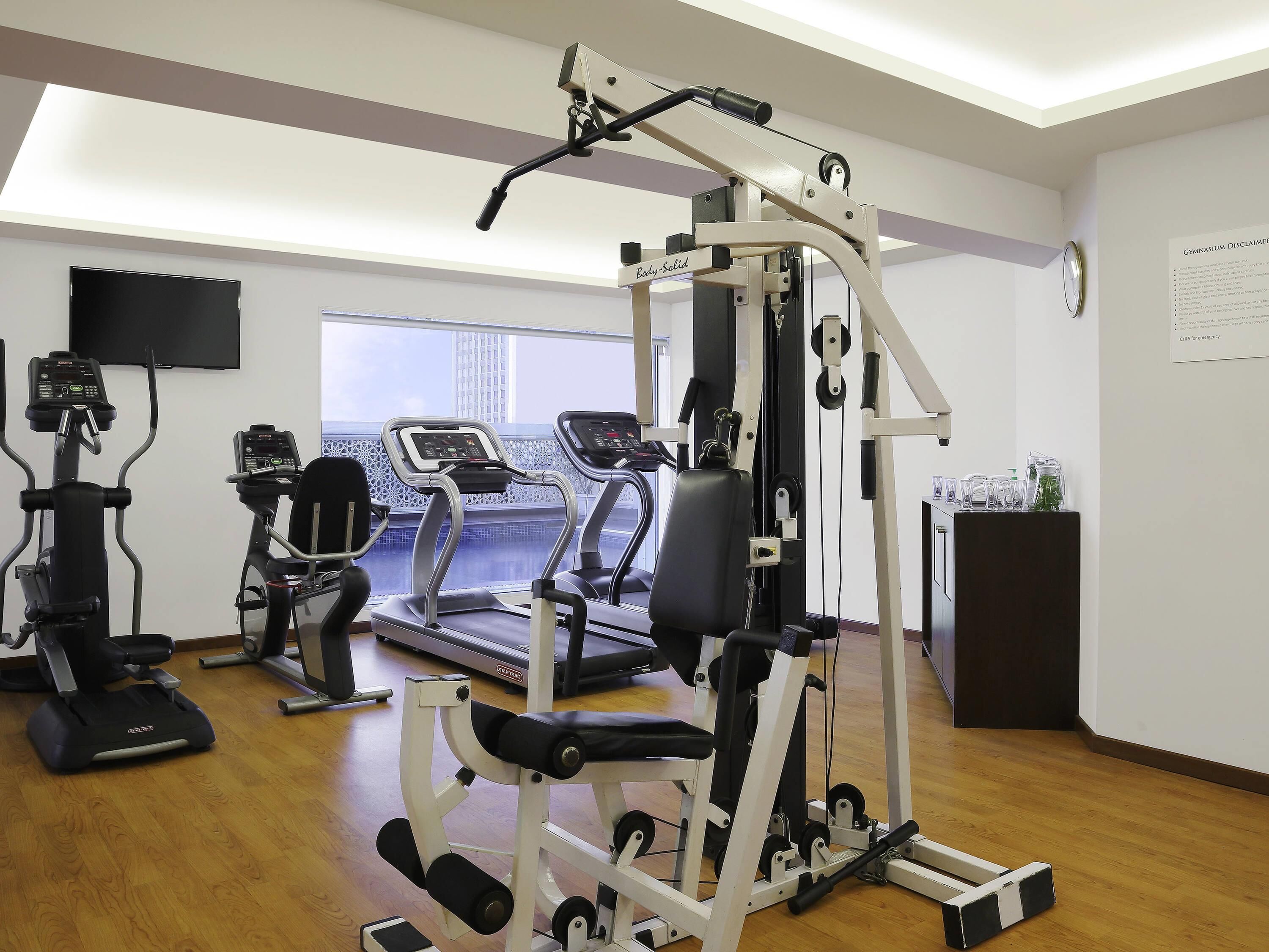 A gym with treadmills, elliptical machines, and weight equipment.