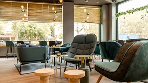 Ett modernt loungeområde med bekväma sittplatser, ett soffbord och en dekorativ hängande lampa.