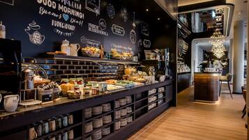 A breakfast buffet with various food items and a coffee station.