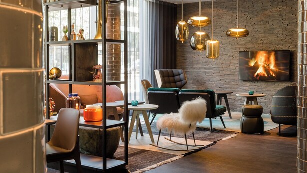 A modern living room with a fireplace, a bookshelf, and contemporary furniture.