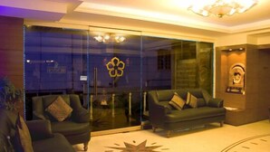A lobby with two sofas, a star-shaped carpet design, and a chandelier. - Ramanashree Brunton (Bengaluru)