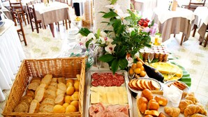 A buffet table with various food items including bread, cheese, meats, and pastries. - Don Pedro Hotel (Ischia)
